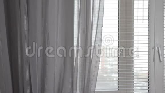 早晨窗上一层透明的灰色窗帘窗帘被风轻轻地吹动视频的预览图