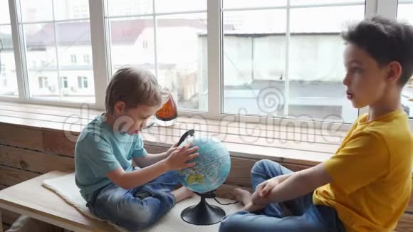 两个男孩用地球仪研究地球的地理视频的预览图