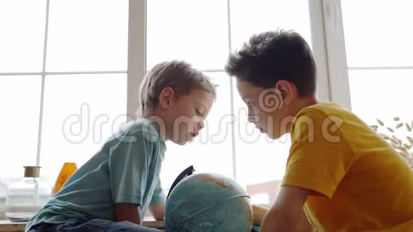两个男孩用地球仪研究地球的地理视频的预览图