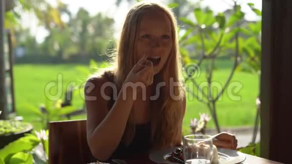 一位年轻女子在日落时分吃晚饭身后有一片稻田视频的预览图