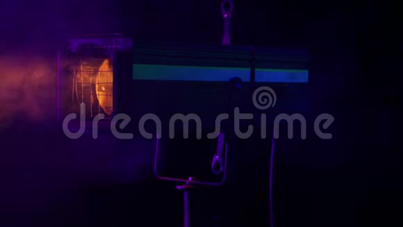 舞台上冷烟云中旋转的舞台轮廓聚光灯的明亮光束视频的预览图