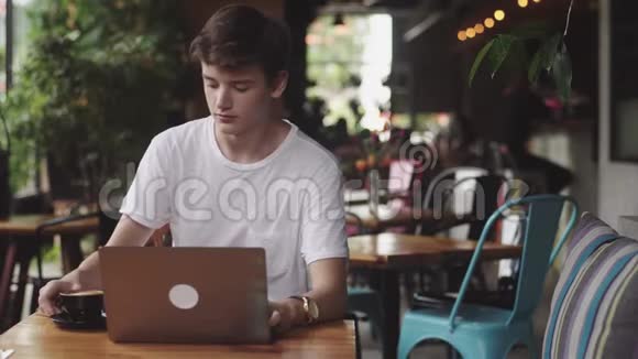 年轻人上网聊天自由职业者和博主在室内做平面设计师喝咖啡视频的预览图