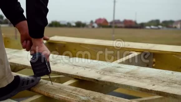 安装旋入式木板的人库存录像男人用螺丝刀把一个螺丝钉拧进板里视频的预览图
