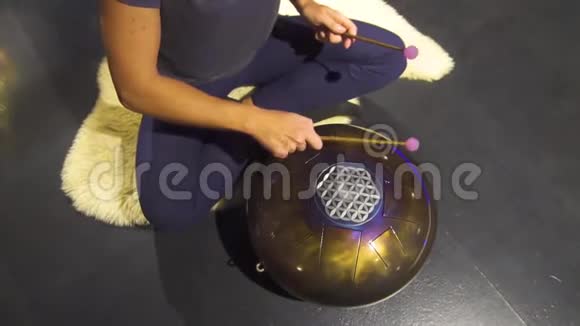 女人在冥想和放松练习中演奏冥想乐器鼓视频的预览图
