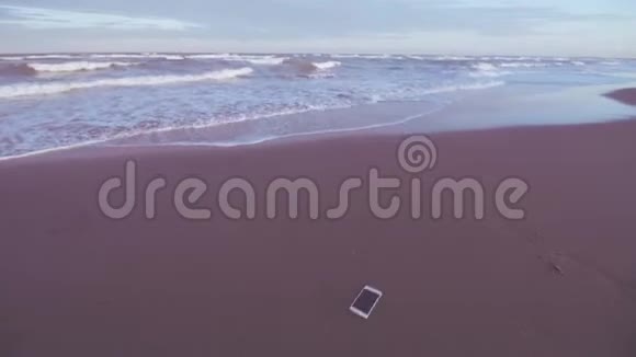 智能手机被扔在沙滩上视频的预览图