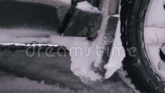 肮脏冰冷的汽车骑在森林道路上松散的深雪上视频的预览图