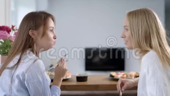 两个女孩的朋友正坐在房间里聊天闲聊从送货服务中吃寿司视频的预览图
