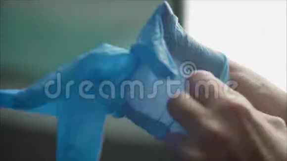 牙医戴蓝色橡胶手套蓝手套穿着医生英俊的年轻医生在医院或诊所戴橡胶手套视频的预览图
