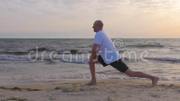 运动员在海边做伸展运动到腿部海浪背景视频的预览图