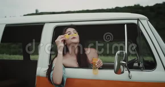 复古巴士里的嬉皮女孩吹泡泡90年代的气氛视频的预览图