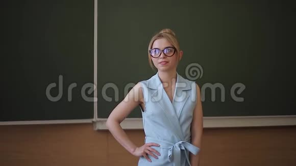 漂亮的女教师站在绿树桌前视频的预览图