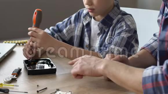 男孩用螺丝刀修理硬盘父亲教给一些建议视频的预览图