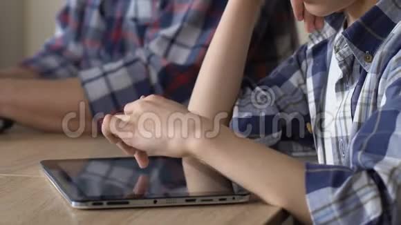 心烦意乱的儿子在平板电脑上滚动照片看着忙碌的父亲忽视了孩子视频的预览图