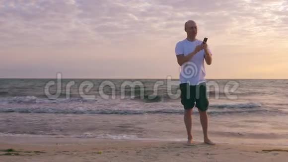 清晨日出时微笑男在背景海景上自拍视频的预览图