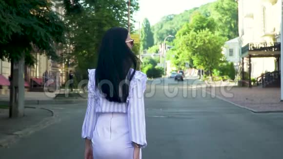漂亮的女人穿着时髦的衣服慢悠悠地走在街上视频的预览图