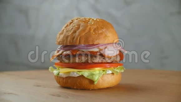 美味的快餐概念新鲜自制烤汉堡肉饼西红柿黄瓜生菜洋葱和芝麻视频的预览图
