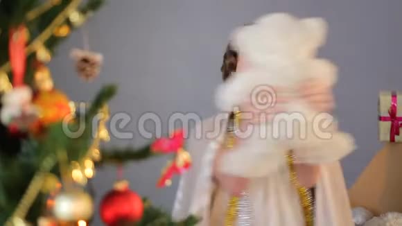 可爱的女孩在圣诞树附近享受节日和玩具跳舞童年视频的预览图
