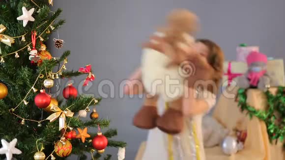 快乐的孩子和毛绒鹿在圣诞树旁跳舞视频的预览图
