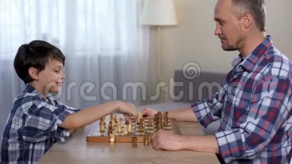 父亲和他聪明的小儿子之间的象棋比赛男孩给爸爸五分钱视频的预览图