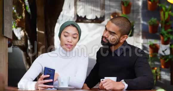 一对夫妇在自助餐厅用手机讨论视频的预览图