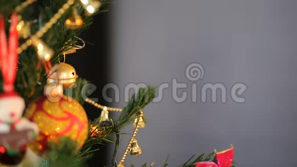 假期前傍晚布鲁内特女孩把圣诞玩具挂在杉树上视频的预览图