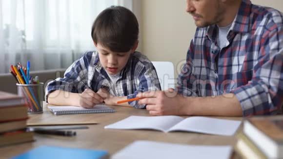 关爱的父亲帮助他的小儿子做家庭作业父亲的支持教育视频的预览图