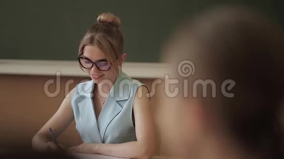女老师在小朋友面前教室里的漂亮老师坐在桌子前问孩子们教育视频的预览图