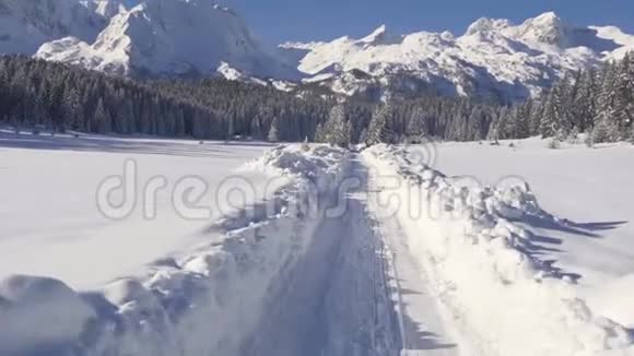 在阳光明媚的一天在冬日的乡间小路上驱车俯瞰群山视频的预览图