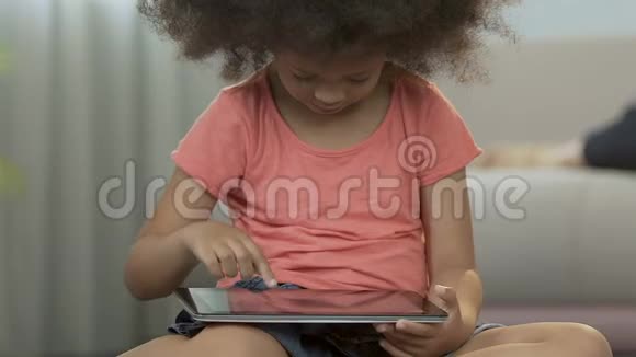 女儿玩平板电脑幸福的父母坐在沙发后面家人视频的预览图