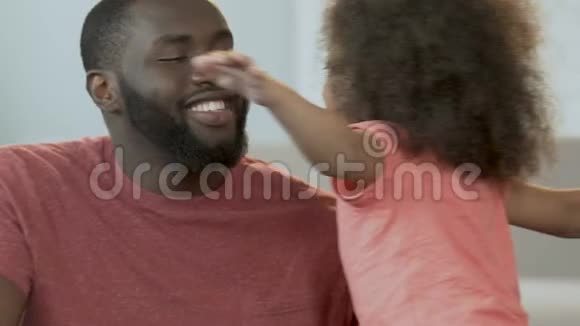 非洲男人拥抱他可爱的女儿微笑父母家庭安慰视频的预览图
