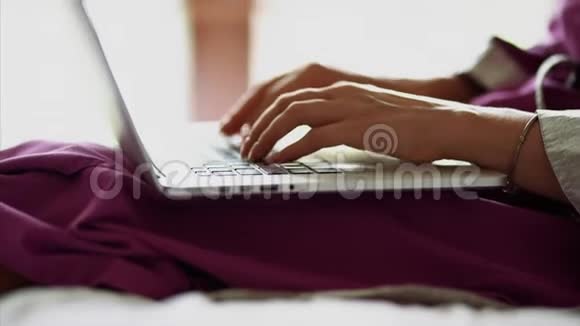 一个快速在笔记本电脑键盘上打印文本的女人的手被近距离射击女士们正在工作视频的预览图