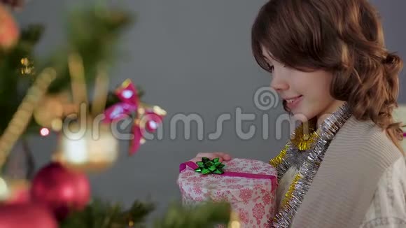 年轻的黑发女孩打开圣诞礼物微笑奇迹和魔法视频的预览图