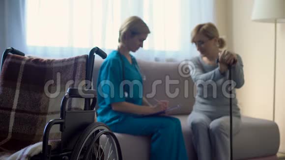 护士和老妇人坐在医院的沙发上讨论新闻支持视频的预览图