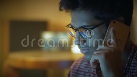 特写镜头美丽的印度男人在眼镜上飞过电话和看电脑屏幕视频的预览图