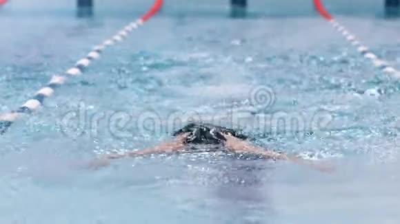 全镜头前景专业男性游泳运动员进行蝶泳训练视频的预览图