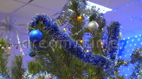 绿色的大的美丽的圣诞树在一个房间装饰着节日五颜六色的球和金属视频的预览图