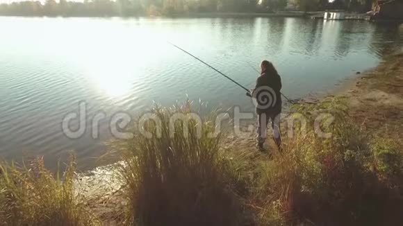 渔夫正在阳光下在河岸上钓鱼长胡子的人在好天气里从岸上钓鱼视频的预览图
