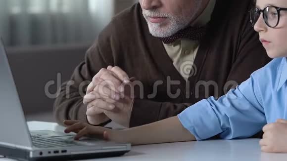 男孩帮助祖父使用电脑家庭和睦聪明的一代视频的预览图