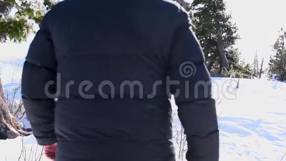 冬天一个人在晴朗的天气里穿过厚厚的雪视频的预览图