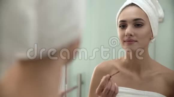 嘴唇化妆女人在浴室用液体唇膏视频的预览图