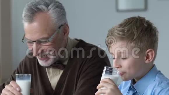 小学生和爷爷早上一起喝牛奶家庭早餐视频的预览图