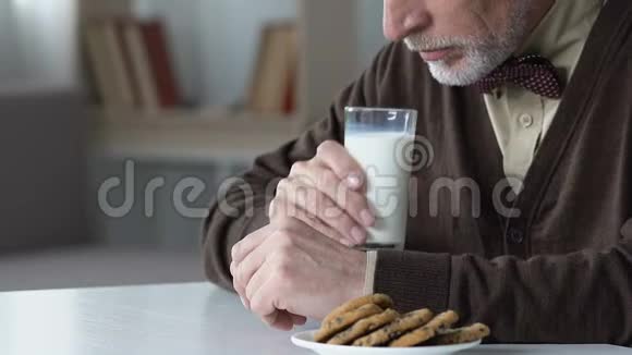 伤心的老人坐在桌旁不肯喝牛奶在养老院不开心视频的预览图