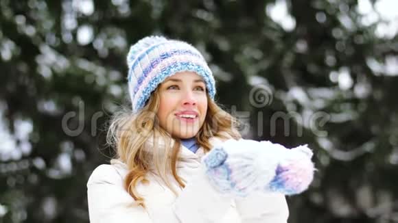 快乐的年轻女子在冬天的森林里吹雪视频的预览图