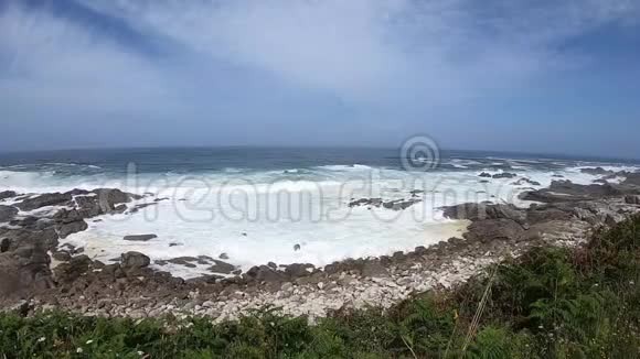 大西洋的景色在去西班牙奥亚的路上阳光明媚的一天海浪水击打岸上的石头视频的预览图