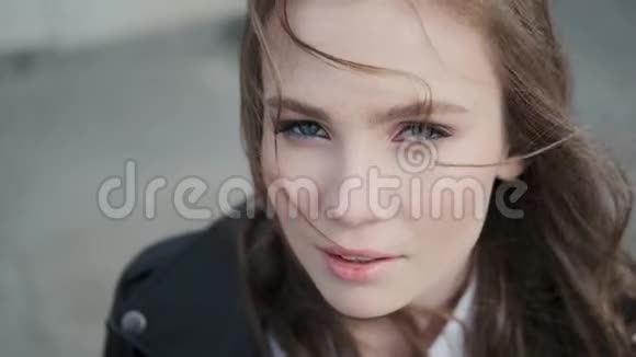 一个蓝眼睛的漂亮女孩的特写肖像嬉皮士看着摄像机视频的预览图