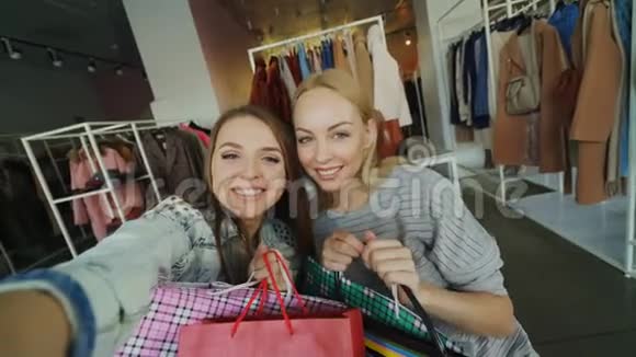 角度拍摄的迷人年轻女士自拍与纸袋在妇女服装精品女孩视频的预览图