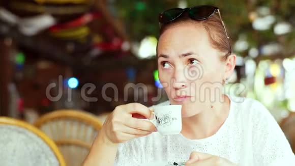 女游客在街头咖啡馆喝咖啡视频的预览图