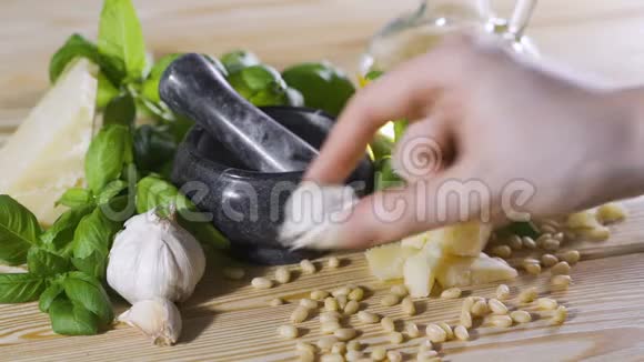 人的手把几瓣大蒜放在桌子上调味酱的配料视频的预览图