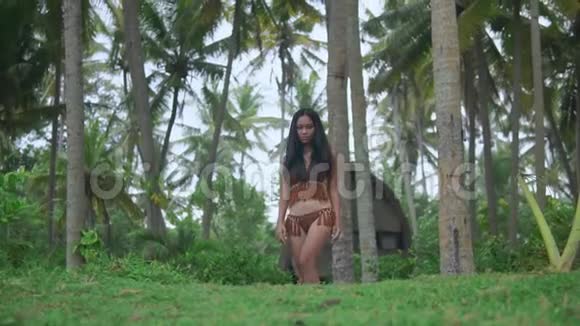 长发黑发女子沿着丛林小道向前走身穿钩编比基尼视频的预览图