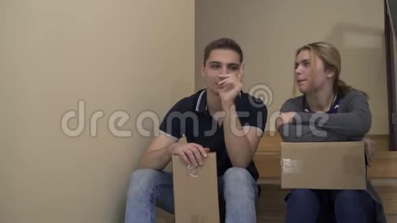 年轻漂亮的夫妇正坐在房子的楼梯上聊天视频的预览图